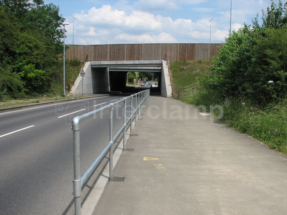 Interclamp standard safety stanchion posts installed along a main road, offering robust protection and guiding pedestrians safely.